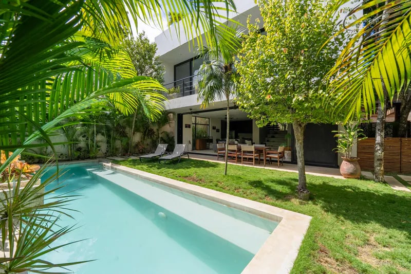 Modern vacation rental and pool surrounded by tropical landscaping