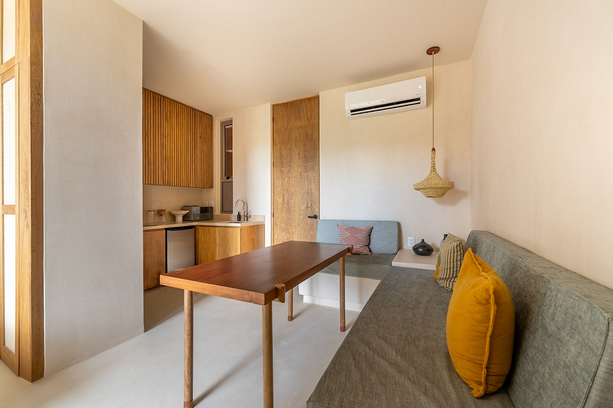 Studio dining nook beside a compact kitchen with wooden cabinets — Aflora 214