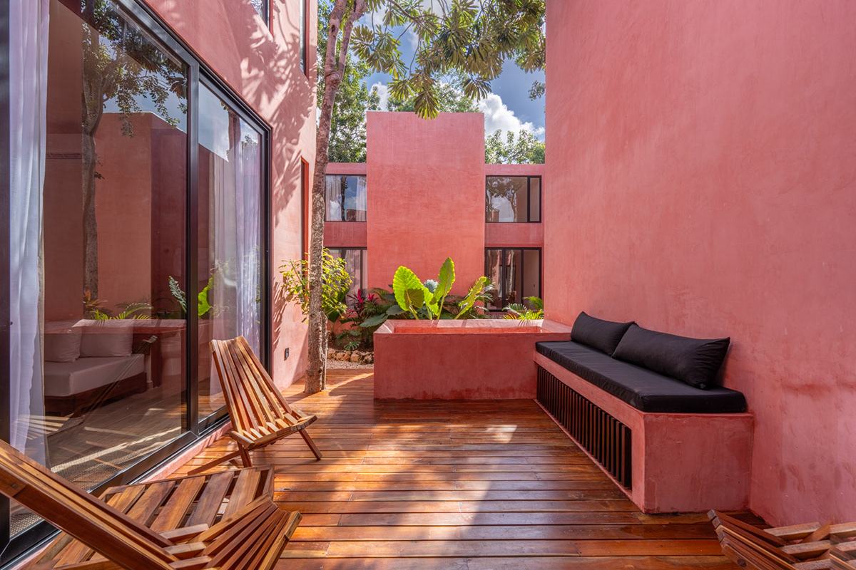 Terracotta-colored courtyard with a wooden deck and outdoor seating — Tulix 8