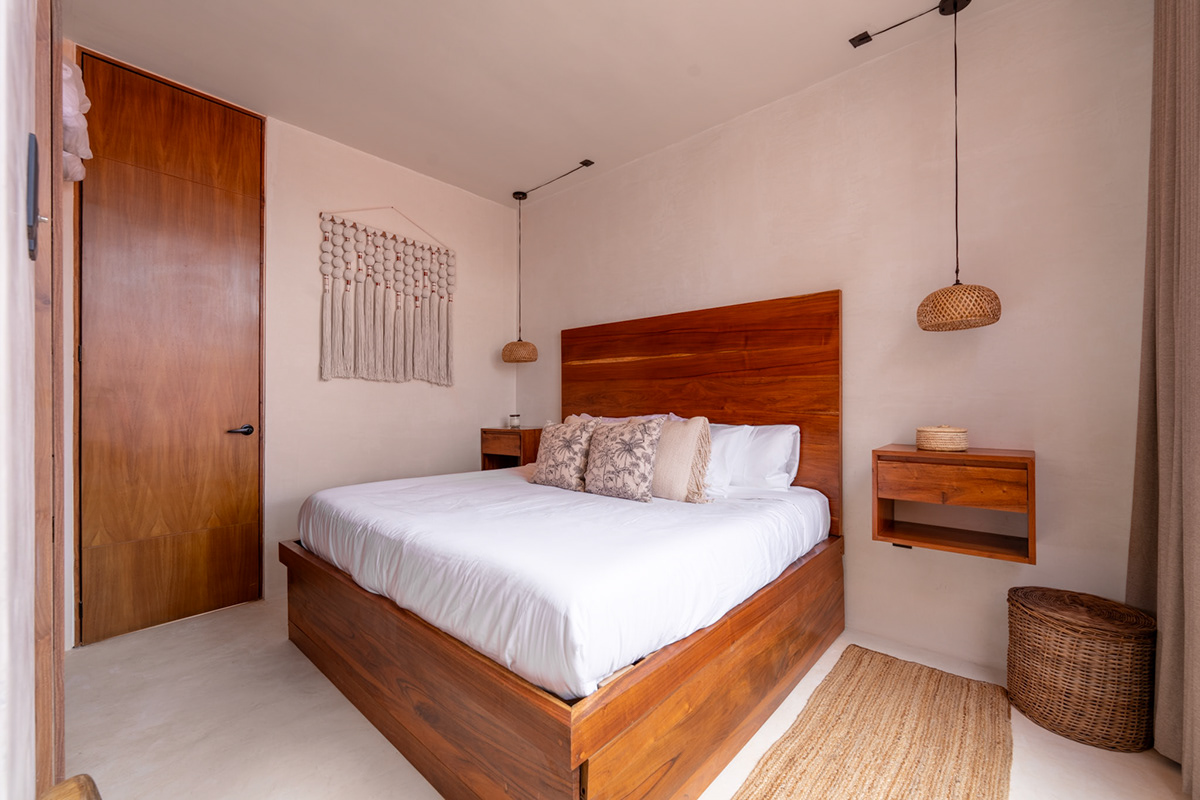 Bedroom with a wooden bed, woven pendant lighting, and a window toward the courtyard — Tulix 9